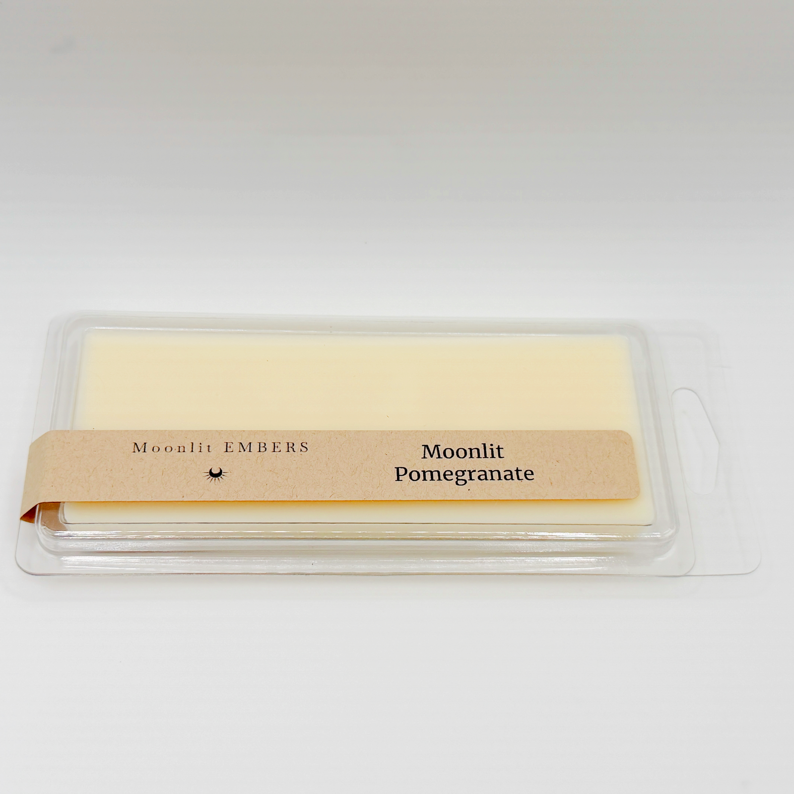 Wax melt in a clear packaging with 'Moonlit Embers' and 'Moonlit Pomegranate' labels on a white background